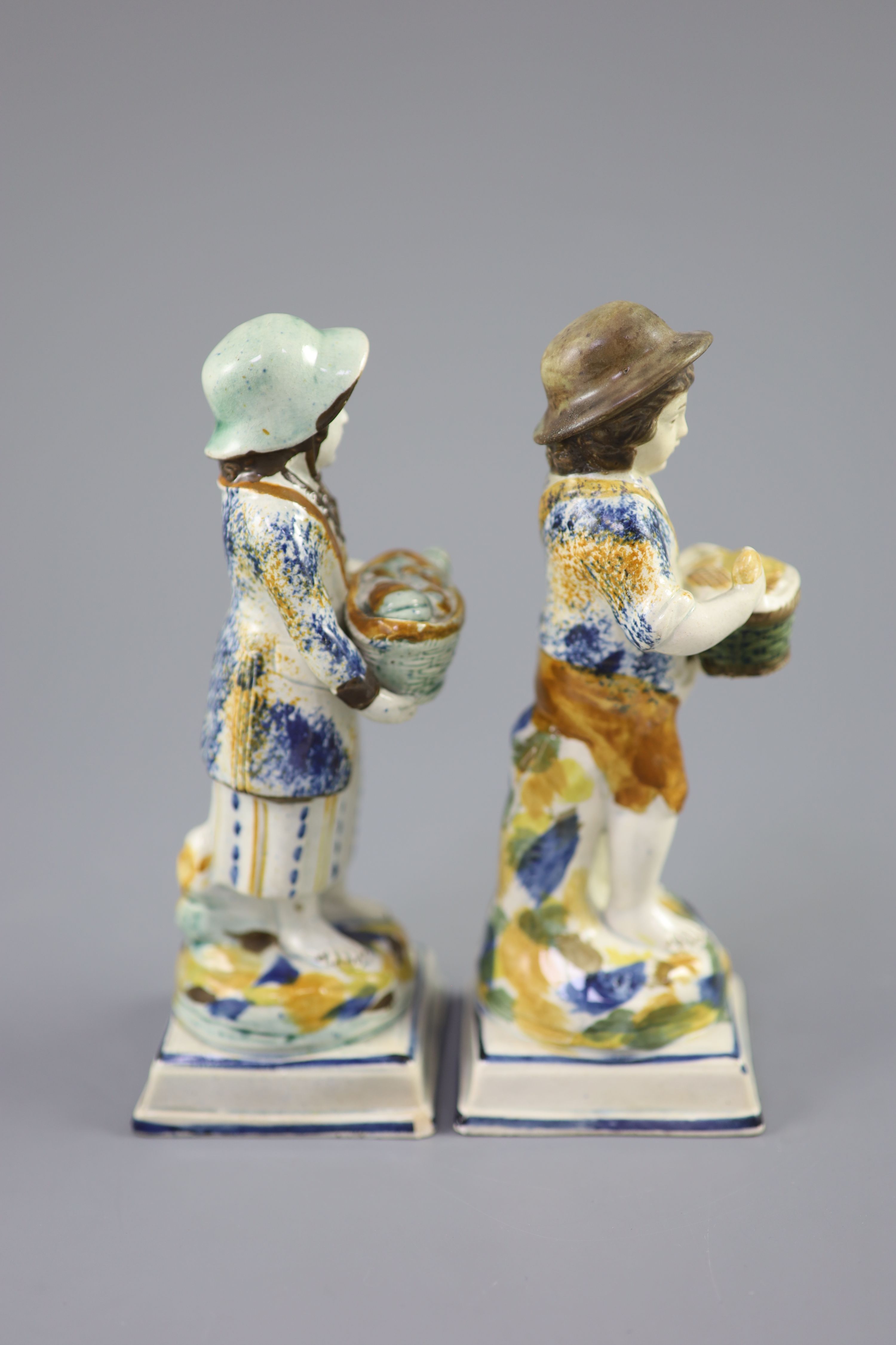 A pair of Prattware figures of fruit and biscuit street vendors, c.1790-1800, 17.5cm high